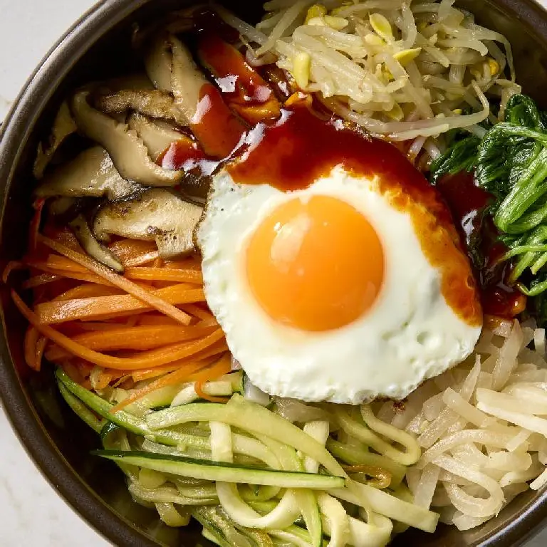 Traditional Korean noodle dish topped with vegetables and egg