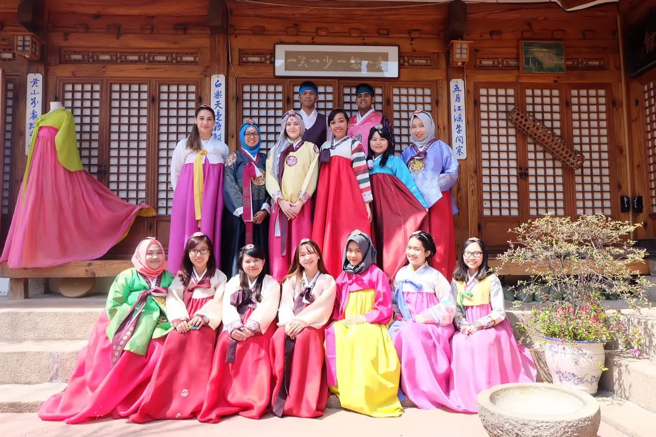 Group wearing traditional Korean hanbok outside a traditional building
